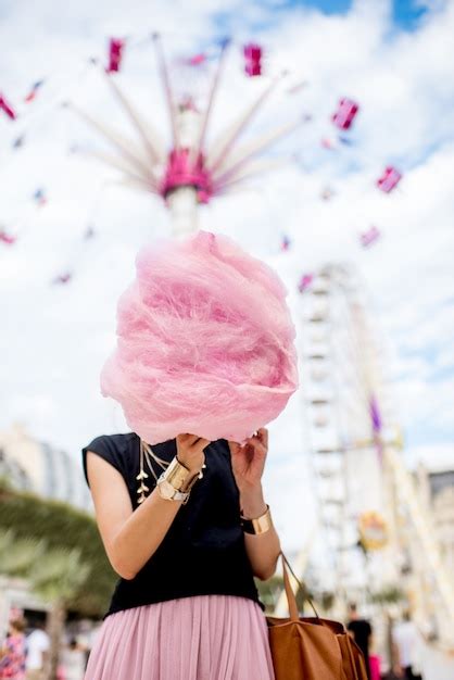 Premium Photo Young Woman Standing With Pink Cotton Candy In Front Of