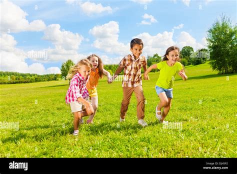 Group of little 6 and 7 years old kids, boys and girls running holding ...