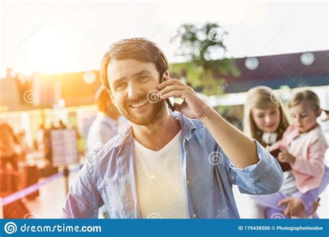 Portrait Of Mature Man Smiling While Talking On Smartphone In Airport