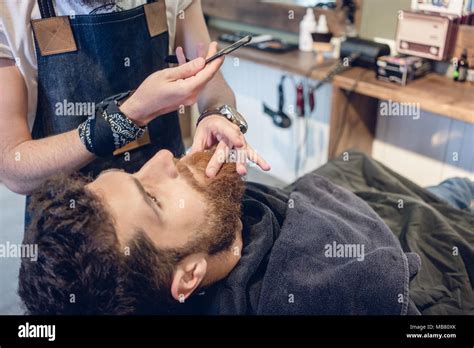 Bearded Young Man Ready For Shaving In The Hair Salon Of A Skilled