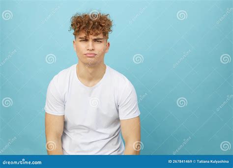 Sad, Gloomy Young Man with Curly Hair Stands on a Light Blue Background ...