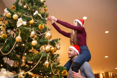 Premium Photo Couple Decorating The Christmas Tree