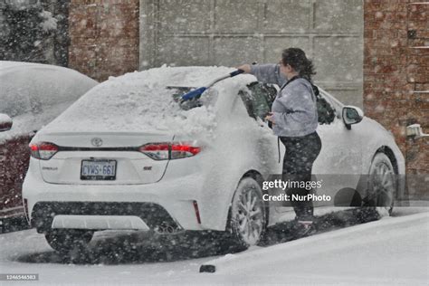 Woman Clears Snow From Her Car As A Massive Snowstorm Hits Toronto