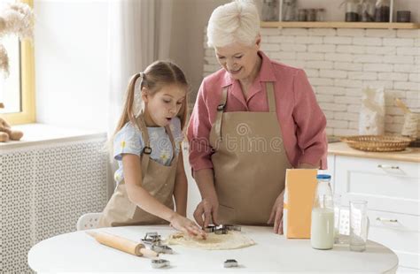 Grandma With Her Cute Little Granddaughter Making Cookies In Sunny