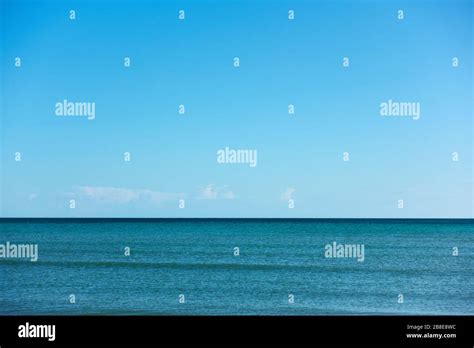 Sea And Almost Clear Sky With A Few Clouds Above Horizon Seascape