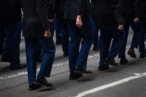 Premium Photo A Group Of People In Blue Uniforms Walk Down A Street