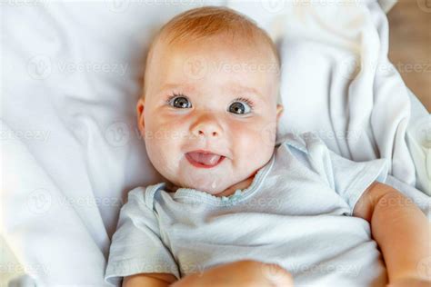 Cute Little Newborn Girl With Smiling Face Looking At Camera On White