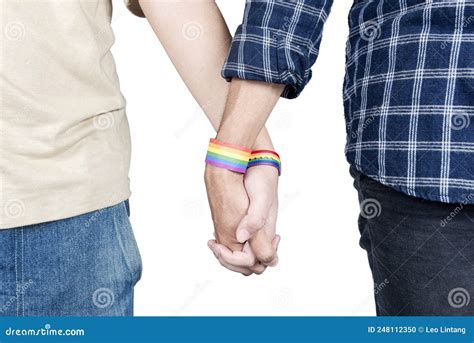 A Gay Couple With An Lgbt Rainbow Flag Wristband Holding Hands Together