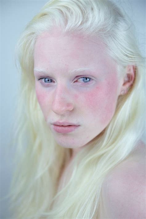 A Woman With Long Blonde Hair And Blue Eyes Is Posing For The Camera While Wearing White Makeup