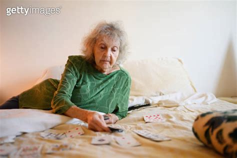 Senior Grandmother Playing Solitare Card Game in Bedroom 이미지