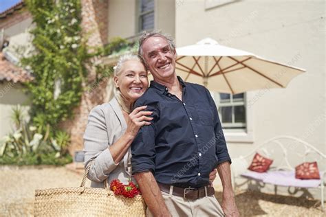 Senior Couple Hugging On Sunny Villa Patio Stock Image F037 9852