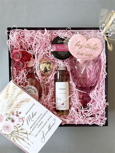 A Pink Gift Box Filled With Wine Chocolates And Other Personalized