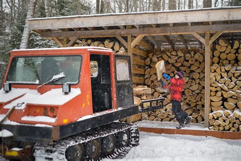 Boy At Wood Shed Has Fun Tossing Firewood Into Bed Of Vintage Orange