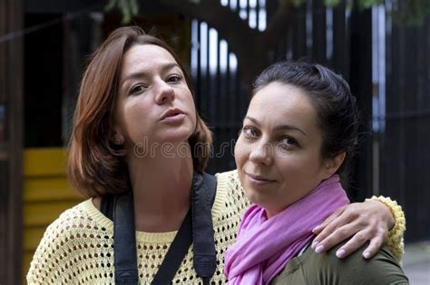 Street Portrait Of Two Serious Women 35 40 Years Old Embracing Each