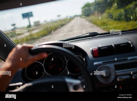 A Man Driving A Car Focus On The Left Hand Held On Steering Wheel