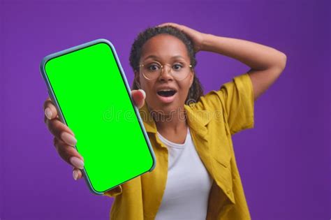 Young Shocked African American Woman Holding Smartphone With Green