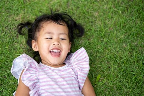 Premium Photo High Angle View Of Cute Girl Lying On Grass