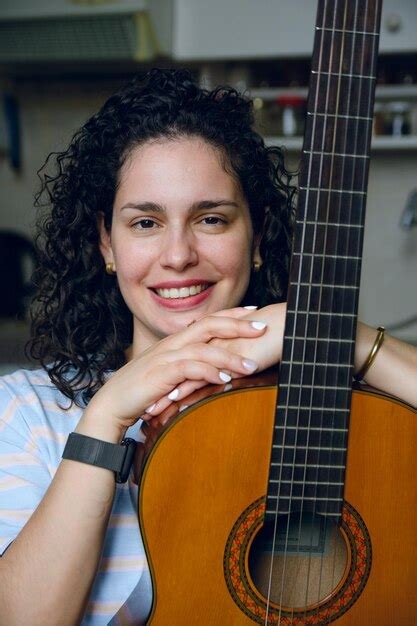 Retrato Vertical De Una Joven Latina Sentada En Casa Sonriendo Con Su
