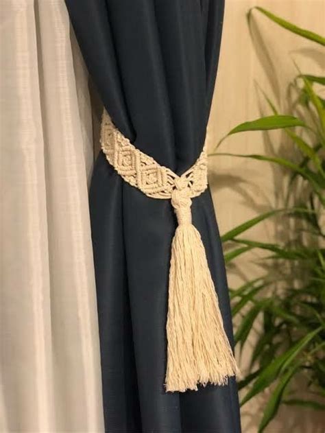 A Curtain With Tassels Hanging From It Next To A Potted Green Plant