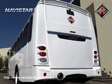 A White Bus Parked In Front Of A Building