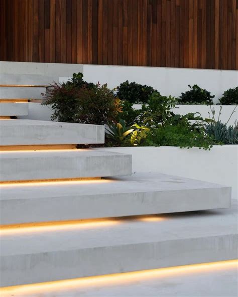 Concrete Steps Lit Up With Led Lights In Front Of A Wall And Planter Area