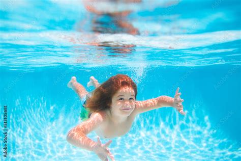 Child swim and dive underwater in the swimming pool. Summer kids ...