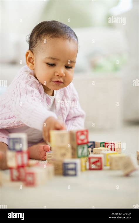 Mixed race baby playing with blocks Stock Photo - Alamy