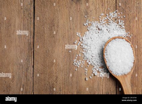 Spoon And Heap Of Natural Sea Salt On Wooden Table Top View Space For