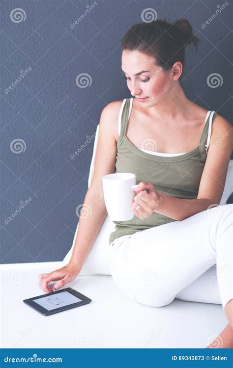 Attractive Caucasian Girl Sitting On Floor With Cup And Tablet Near