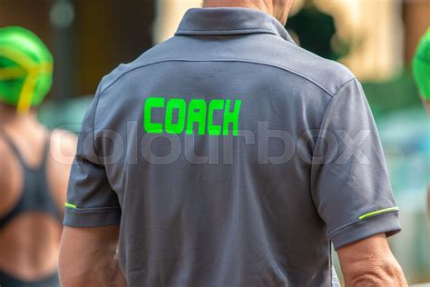 Back View Of Male Swimming Coaches Wearing Coach Shirt At Outdoor