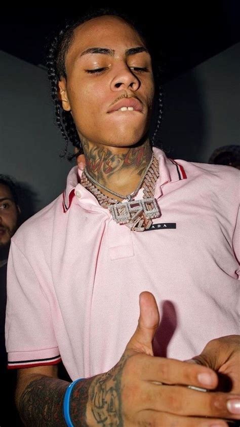 A Man With His Eyes Closed Wearing A Pink Polo Shirt And Tattoos On His Arm