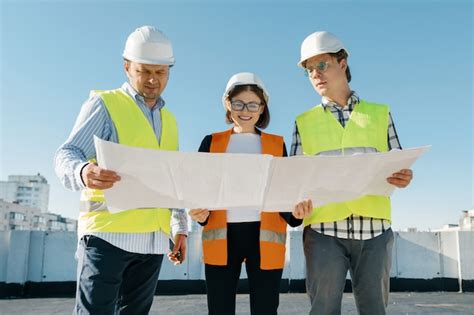 Equipo de ingenieros constructores en un sitio de construcción leyendo