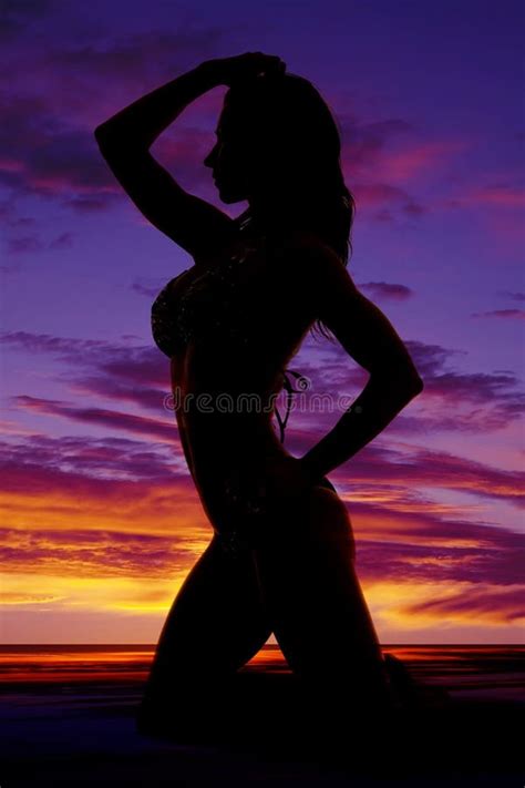 Silhouette Of A Woman In A Bikini On Knees Fromn Side Stock Photo