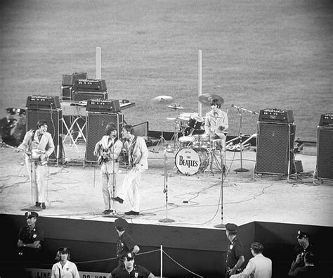 the beatles performing on stage at an outdoor concert