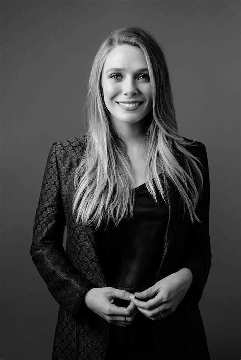 A Black And White Photo Of A Woman With Long Blonde Hair Wearing A Blazer