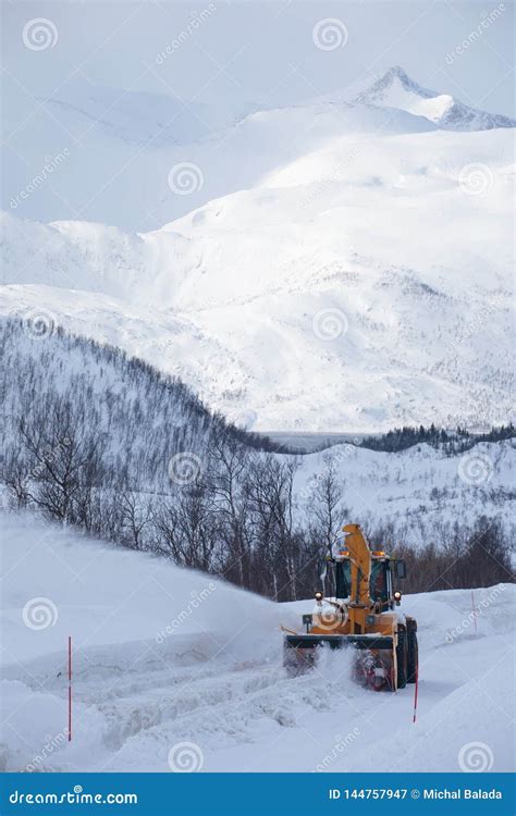 Snow Plow Truck Clearing Icy Road After Winter Snowstorm Blizzard For