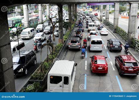 Private And Public Vehicles Pass Along A Traffic Congested Major