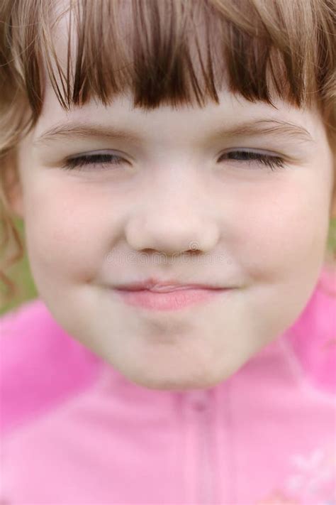 Feche Acima Da Menina Fazendo Caretas Feliz Bonita Pequena Da Cara Foto