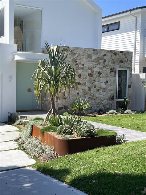 A House That Has Some Plants In Front Of It