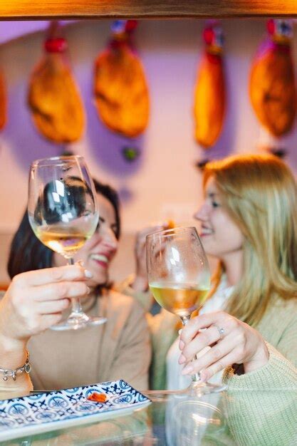 Premium Photo Two Women Toasting With Wine Glasses In A Restaurant