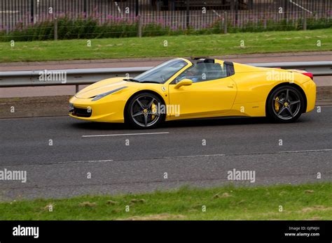 A Yellow Ferrari 458 Italia Spider Convertible Sports Car Travelling Along The Kingsway West