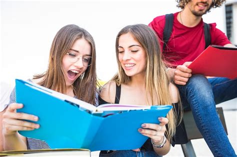 Free Photo Excited Women Reading Textbook Near Man