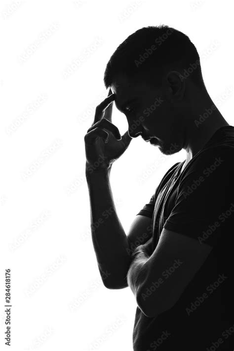 Silhouette Portrait Profile Of A Thinking Young Man Holding His Hand To