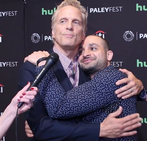 Two Men Hugging Each Other In Front Of A Microphone