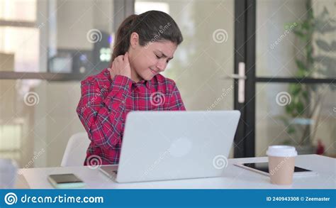 Indian Woman Having Neck Pain While Typing On Laptop Stock Photo