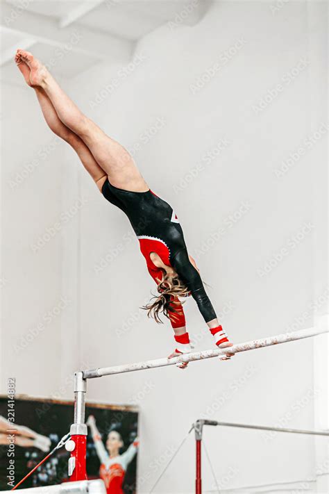 young woman gymnast exercise on uneven bars in gymnastics Stock Photo | Adobe Stock