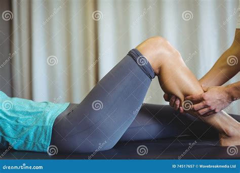 Male Physiotherapist Giving Leg Massage To Female Patient Stock Image