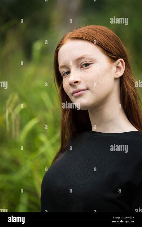 Red Haired Twelve Year Old Girl With Freckles Posing With A Nature