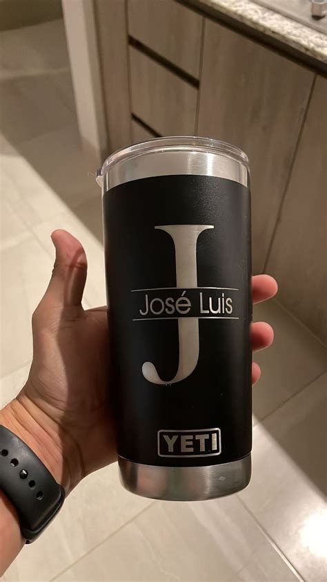 A Person Holding Up A Tumbler Cup With The J On It S Side