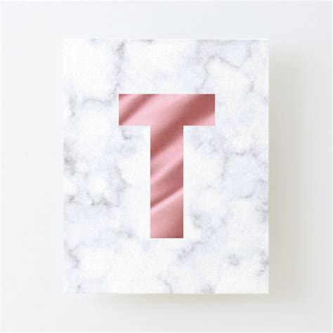 The Letter T Is Made Up Of White Marble And Pink Foil On Top Of It